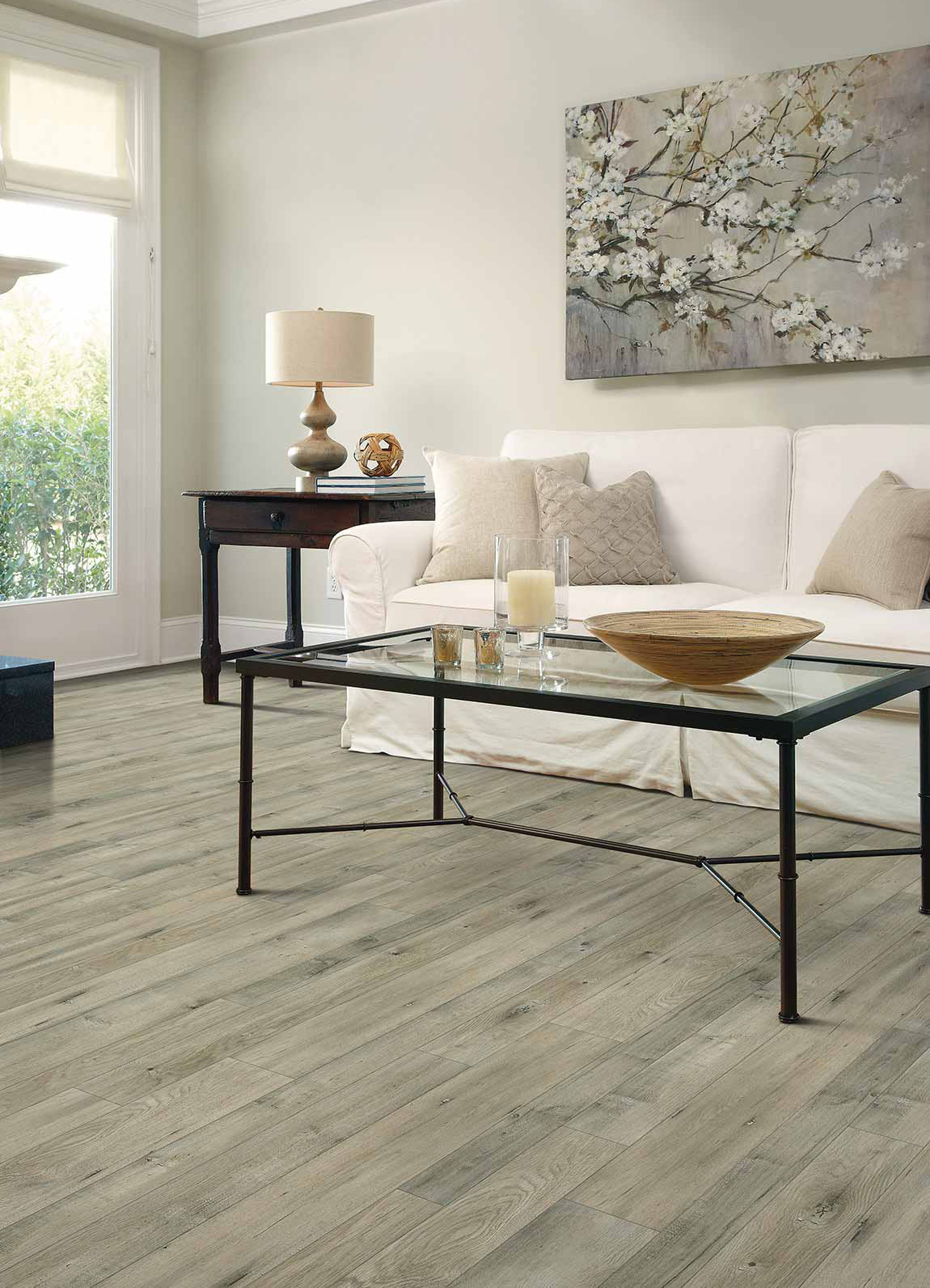 Floorcraft Laminate Majestic Pear, laminate in living room scene with glass coffee table, white couch and wall art.